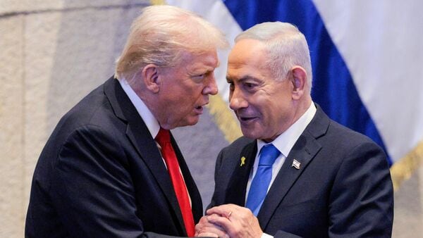 US President Donald Trump (L) holds hands and speaks with Israeli Prime Minister Benjamin Netanyahu