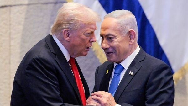 US President Donald Trump (L) holds hands and speaks with Israeli Prime Minister Benjamin Netanyahu