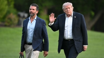 Donald Trump and Donald Trump Jr. walk on the south lawn toward the White House in Washington, DC (AFP)