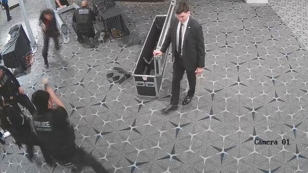An officer fires (bottom L) as White House Correspondents' Association Dinner shooting suspect Cole Tomas Allen sprints past security personnel in a screengrab form security camera video, at Washington Hilton Hotel, Washington D.C., U.S., April 25, 2026.  U.S. Attorney Jeanine Pirro via X/Handout via REUTERS