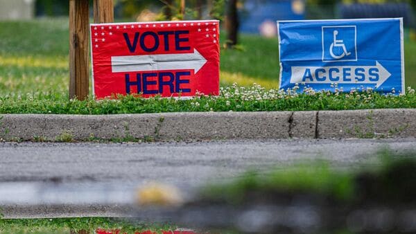 A VOTE HERE sign is seen at the parking entrance of Shelby Traditional Academy on May 19, 2026 in Louisville, Kentucky.  Jon Cherry/Getty Images/AFP
