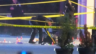 U.S. Secret Service Police examine and photograph evidence at a crime scene near the White House, Saturday, May 23, 2026, in Washington. The U.S. Secret Service shot a person near the White House on Saturday, and a bystander also was shot, a law enforcement official said. (AP Photo/Alex Brandon) (AP Photo/Alex Brandon)