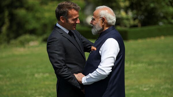 French President Emmanuel Macron, left, and India's Prime Minister Narendra Modi greet each other ahead of a group photo at the G7 summit in Evian-les-Bains, France
