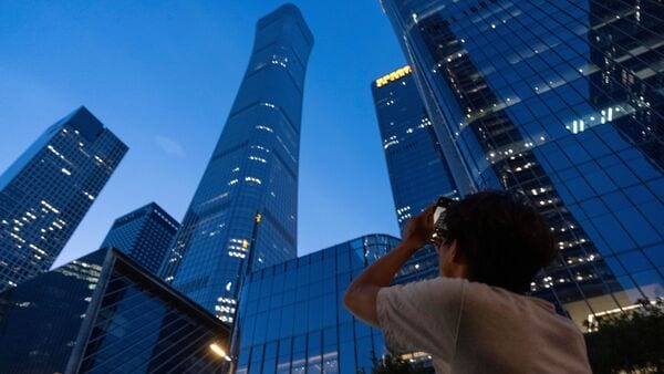 Latest news on June 26, 2026: A passerby tries to take photo of the damage on the Citic Tower also known as Zun Tower in Beijing, Cina, Friday, June 26, 2026. (AP Photo/Han Guan Ng)