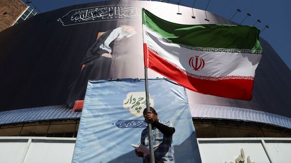 A man holds an Iranian flag on a street, after U.S. and Iranian officials said they had reached a deal to end their war and reopen the Strait of Hormuz, in Tehran, Iran, June 15, 2026.
