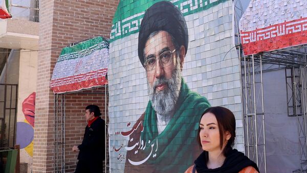 Tehran's Supreme Leader, Ayatollah Seyed Mojtaba Khamenei, has reportedly called on the Islamic Republic's judiciary to pursue and restore the nation’s rights | A woman in front of an image of Iran's current leader, Ayatollah Mojtaba Khamenei. (File Photo: AFP)