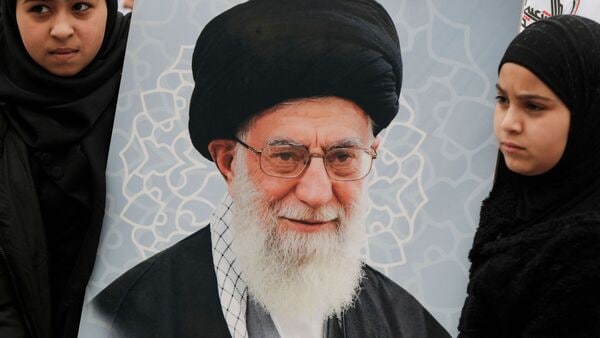 Schoolgirls display a poster of slain Iranian supreme leader Ayatollah Ali Khamenei during an anti-US and Israeli demonstration in Baghdad on March 12, 2026.