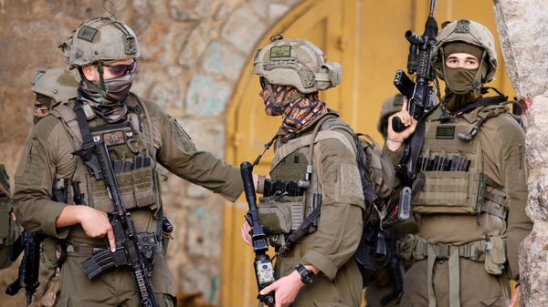 Israeli soldiers stand guard during a weekly settlers' tour in Hebron, in the Israeli-occupied West Bank, May 16, 2026.