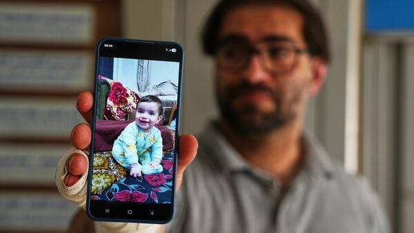 Fahd Abu Haikal, 41 displays a mobile photo of his seven month old Palestinian baby boy Sam, who was killed on Friday when Israeli soldiers fired at the vehicle carrying him and his parents, in Tel Rumeida, at a hospital in the West Bank city of Hebron Saturday, June 6, 2026.
