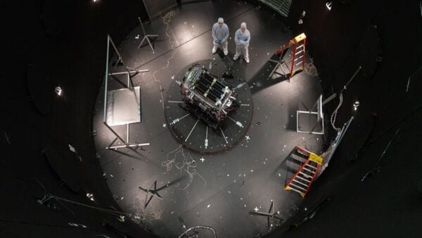 This photo provided by NASA shows Kieran Wilson, LINK’s principal investigator, and Hunter Robertson, a space systems engineer, both at Katalyst Space, standing next to their spacecraft inside the SES (Space Environment Simulator) at NASA’s Goddard Space Flight Center in Greenbelt, Md., April 17, 2026, ahead of thermal vacuum testing. (Sophia Roberts/NASA via AP)