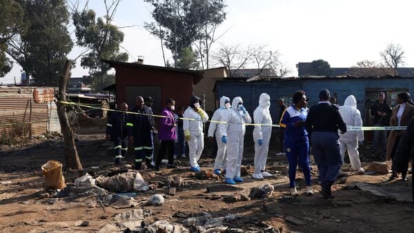 Members of the forensics team arrive at the scene after, according to the police, gunmen opened fire at an informal settlement in Cleveland, Johannesburg, South Africa,