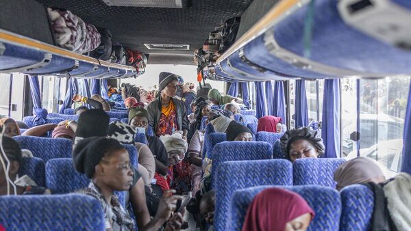 Migrants pack their goods as they board the first of seven buses at the Sherwood Park in Durban on June 14, 2026 to travel back to Malawi.