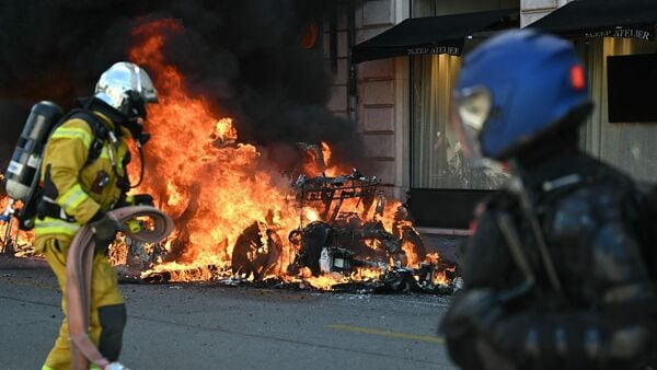 This photograph shows a burning Tesla car during a rally of a 'No-G7' coalition of over 60 associations, unions, and left-wing groups against fascism and imperialism, a day ahead of the summit's start, in Geneva on June 14, 2026.