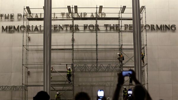 Workers construct scaffolding below the sign for the John F. Kennedy Center for the Performing Arts, Friday, June 12, 2026, in Washington. (AP Photo/Rahmat Gul)