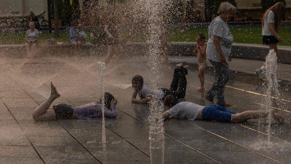 Children play in a fountain on a hot summer day as the European heatwave shifts east to the Balkans and Ukraine, in Kyiv on June 29, 2026, amid the Russian invasion of Ukraine. (Photo by Roman PILIPEY / AFP)