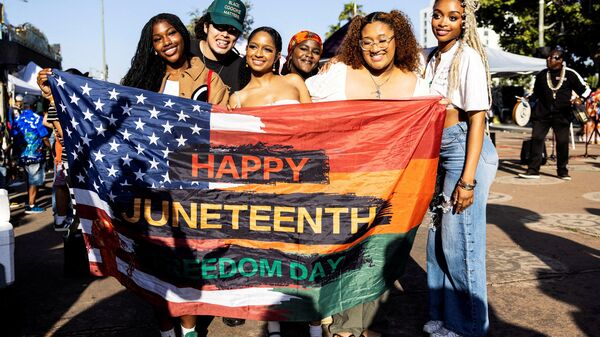 People pose for a picture during a gathering to mark Juneteenth, which commemorates the end of slavery in Texas, over two years after the 1863 Emancipation Proclamation freed slaves elsewhere in the U.S., in Leimert Park, in Los Angeles, U.S., June 19, 2024. REUTERS/Aude Guerrucci/File Photo