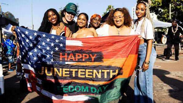 People pose for a picture during a gathering to mark Juneteenth, which commemorates the end of slavery in Texas, over two years after the 1863 Emancipation Proclamation freed slaves elsewhere in the U.S., in Leimert Park, in Los Angeles, U.S., June 19, 2024. REUTERS/Aude Guerrucci/File Photo