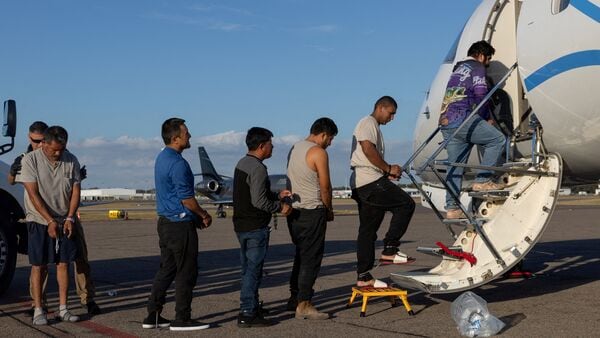 A file image of Immigrants in detention shackles, deemed eligible for an expedited order of removal, boarding an air transport by the US Immigration and Customs Enforcement (ICE) at an airport in Tampa, Florida.