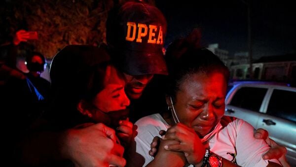 Family members and neighbors of Jhonquer Cerpas, 13, react during his rescue, as rescue operations continue, after earthquakes hit the country, in La Guaira, Venezuela, June 27, 2026.