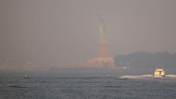 Haze from Canadian wildfires obscures the Statue of Liberty as seen from Brooklyn Bridge Park on July 17, 2026 in New York City. Spencer Platt/Getty Images/AFP