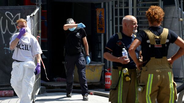 A member of the police walks, following a fire at Oxy Brussels building in Brussels, Belgium, July 14, 2026