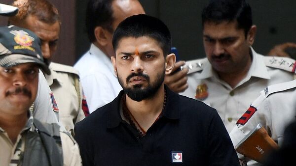 Policemen escort Lawrence Bishnoi at a court in New Delhi, India, in 2023.