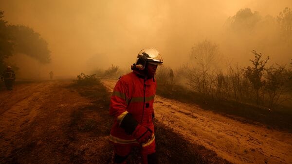 A firefighter walks amid smoke from a wildfire in Lege-Cap-Ferret in the Gironde department, amongst worsening drought conditions following a heatwave and water shortages across much of France, July 24, 2026. REUTERS/Stephane Mahe     TPX IMAGES OF THE DAY