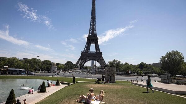 Women sunbathe at the Jardin du Trocadero, near the Eiffel Tower in Paris on July 10, 2026, as a new heatwave hits France. (Photo by Behrouz MEHRI / AFP)