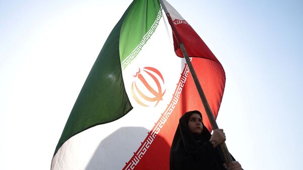 A woman holds an Iranian flag on a street in Tehran, Iran | Representational image