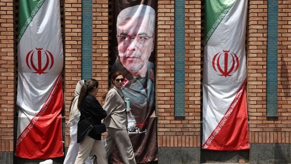Iranian women walk past a banner with a picture of the former Chief of Staff of the Iranian Armed Forces, Mohammad Bagheri, in Tehran, Iran, July 20, 2026. Majid Asgaripour/WANA (West Asia News Agency) via REUTERS
