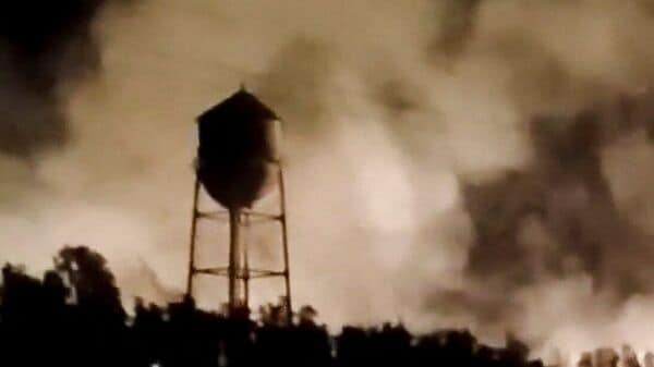 A water tower is silhouetted against smoke rising from a fire following a reported strike in Behbahan, Khuzestan Province, Iran, in this still image obtained from social media video released July 22, 2026