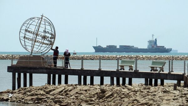 FILE PHOTO: A container ship enters the Singapore Strait for the Strait of Malacca, as tourists stand at mainland Asia's southern most point in Johor, Malaysia November 12, 2016. Picture taken November 12, 2016.  REUTERS/Henning Gloystein/File Photo