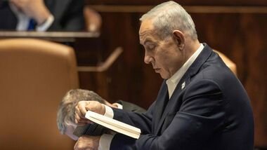 Israel's Prime Minister Benjamin Netanyahu reads a book at the Knesset during a session of the Israeli Parliament in Jerusalem on July 16, 2026, before the start of the election recess ahead of the October 27 general election. (Photo by ilia YEFIMOVICH / AFP)