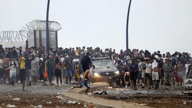 People gather at the site of clashes near Fnideq, on the Morocco-Spain border, on July 31, 2026. Thousands of migrants crossed overnight from Morocco into Spain's north Africa's Ceuta enclave, a police source said on July 31, as Prime Minister Pedro Sanchez was set to arrive to manage the latest migrant crisis on the border. (Photo by Abdel Majid BZIOUAT / AFP)
