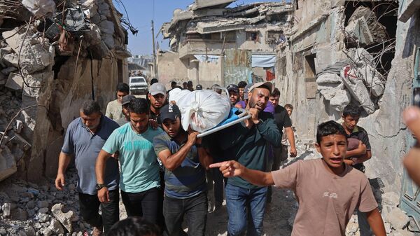 Mourners carry the body of Fadi Daghmash, a Palestinian man who was reportedly killed along with his wife in an Israeli bombardment in the Sabra neighbourhood, during the funeral procession in the Gaza City on July 6, 2026. Since the start of the Gaza war in October 2023, violence has escalated in the West Bank, which Israel has occupied since 1967.