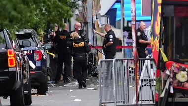 A crime scene photographer arrives as law enforcement examines the scene following a shooting at Seattle Center during the Bite of Seattle food festival Sunday, July 26, 2026, in Seattle. (AP Photo/Lindsey Wasson)