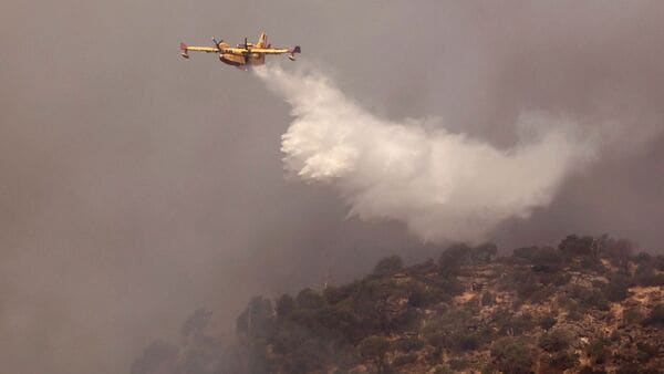 A Canadair firefighting aircraft fights a wildfire burning near Pelayos de la Presa, 65 kilometers west of Madrid, on July 26, 2026. (Photo by Oscar DEL POZO / AFP)
