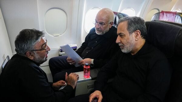 File image released by the office of the Speaker of the Iranian Parliament shows Iranian Parliament Speaker and Iran negotiating team head Mohammad Bagher Ghalibaf (C) and Iranian Foreign Minister Abbas Araghchi (R) speaking with a member of the Iranian delegation aboard a flight en route to Zurich on June 21, 2026.