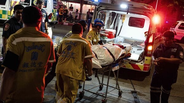 Emergency workers prepare to place the body of a victim into an ambulance in Bangkok early on July 13, 2026, after a fire in the Rong Beer Na Lat Phrao bar killed at least 27 people late Sunday night,