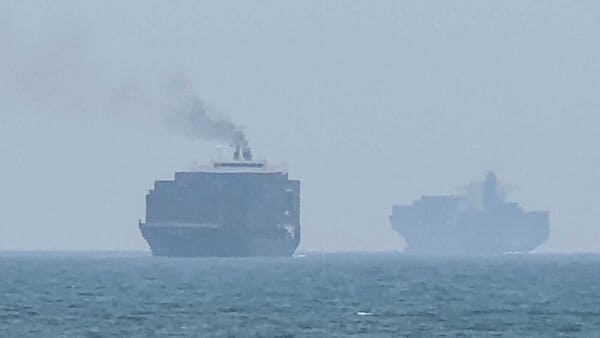 This frame grab taken from AFPTV video footage on July 12, 2026 shows cargo ships anchoring near the Strait of Hormuz off the eastern coast of the United Arab Emirates at Khor Fakkan. (Photo by AFPTV / AFP)