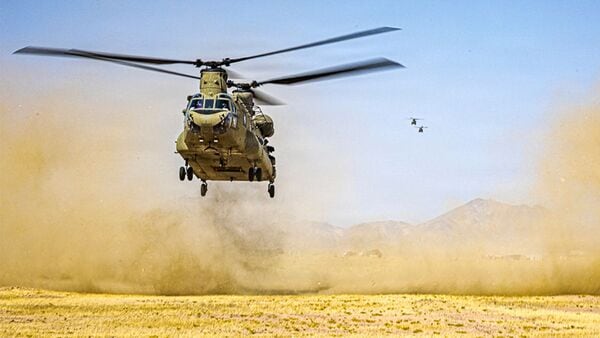 This US Army handout photo released on July 15, 2026 by US Central Command Public Affairs shows three US Army CH-47 Chinook helicopters preparing to land in the Middle East during routine flight operations. (Photo by US ARMY / AFP)