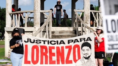 People hold signs in Hidalgo Park during a rally to protest the killing of Lorenzo Salgado Araujo in Houston, Texas, on July 24 (Photo by Mark Felix / AFP) (AFP)