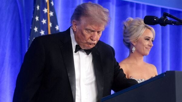 U.S. President Donald Trump, with incoming White House Correspondents' Association (WHCA) President and Fox News Senior White House Correspondent Jacqui Heinrich, takes the lectern to deliver remarks at the WHCA Dinner, which was rescheduled from April after it was interrupted when a man tried to force his way through security and fired a shotgun, at the Waldorf Astoria hotel in Washington, D.C., U.S.,