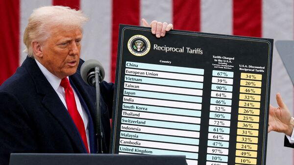 FILE PHOTO: U.S. President Donald Trump holds a chart next to U.S. Secretary of Commerce Howard Lutnick as Trump delivers remarks on tariffs in the Rose Garden at the White House in Washington, D.C., U.S., April 2, 2025. REUTERS/Carlos Barria//File Photo/File Photo