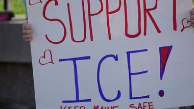 FILE - A woman holds a sign in support in support of U.S. Immigration and Customs Enforcement, outside the State House in Augusta, Maine, July 15, 2026. (AP Photo/Robert F. Bukaty, File)