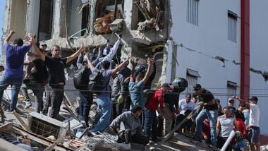 Residents and rescue workers search through the rubble of a collapsed building after an earthquake struck Cali, Colombia