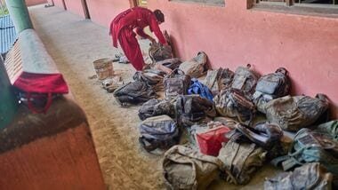 A mother searches for her child's bag from a pile extracted from the mud brought in by the recent flash floods, at the Shree Bagheswori Madhyamik School in Galchhi, Dhading district of Nepal Sunday, Aug. 30, 2026.  AP/PTI