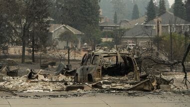 A vehicle and structure are burned on N. Skyline Dr. due to a wildfire, Sunday, Aug. 2, 2026, in Spokane, Wash.