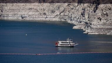 A paddle boat in Lake Mead near the Hoover Dam, far below the bathtub ring of light minerals indicating the lack of water, near Boulder City, Nev., on Friday, Aug. 7, 2026. (AP Photo/Ty ONeil)