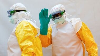 A health worker wearing Personal Protective Equipment (PPE) waves as they walk in a formation during a training by Medecins Sans Frontieres (MSF) for personnel preparing to reinforce regional Ebola response capacity in the Democratic Republic of Congo amid an outbreak of the Bundibugyo strain, at an Ebola simulation treatment center set up by MSF in Kajiado County near Nairobi, Kenya, August 5, 2026. REUTERS/Thomas Mukoya